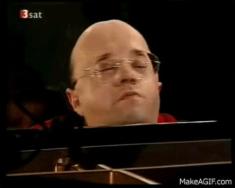 Bald man with glasses in a broadcast setting