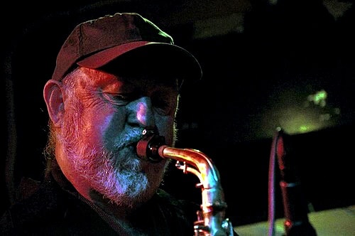 Saxophonist under moody lighting