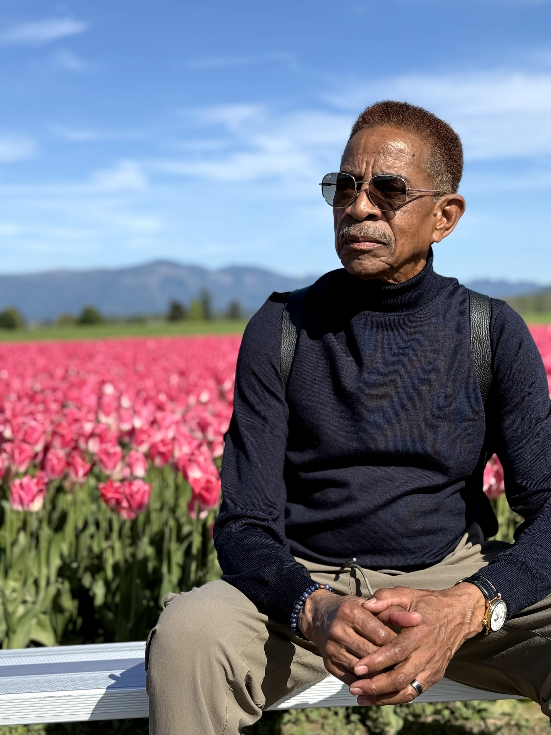 Robert N. Warfield, founder of the Seattle Jazz Heritage Institute, seated in a tulip field